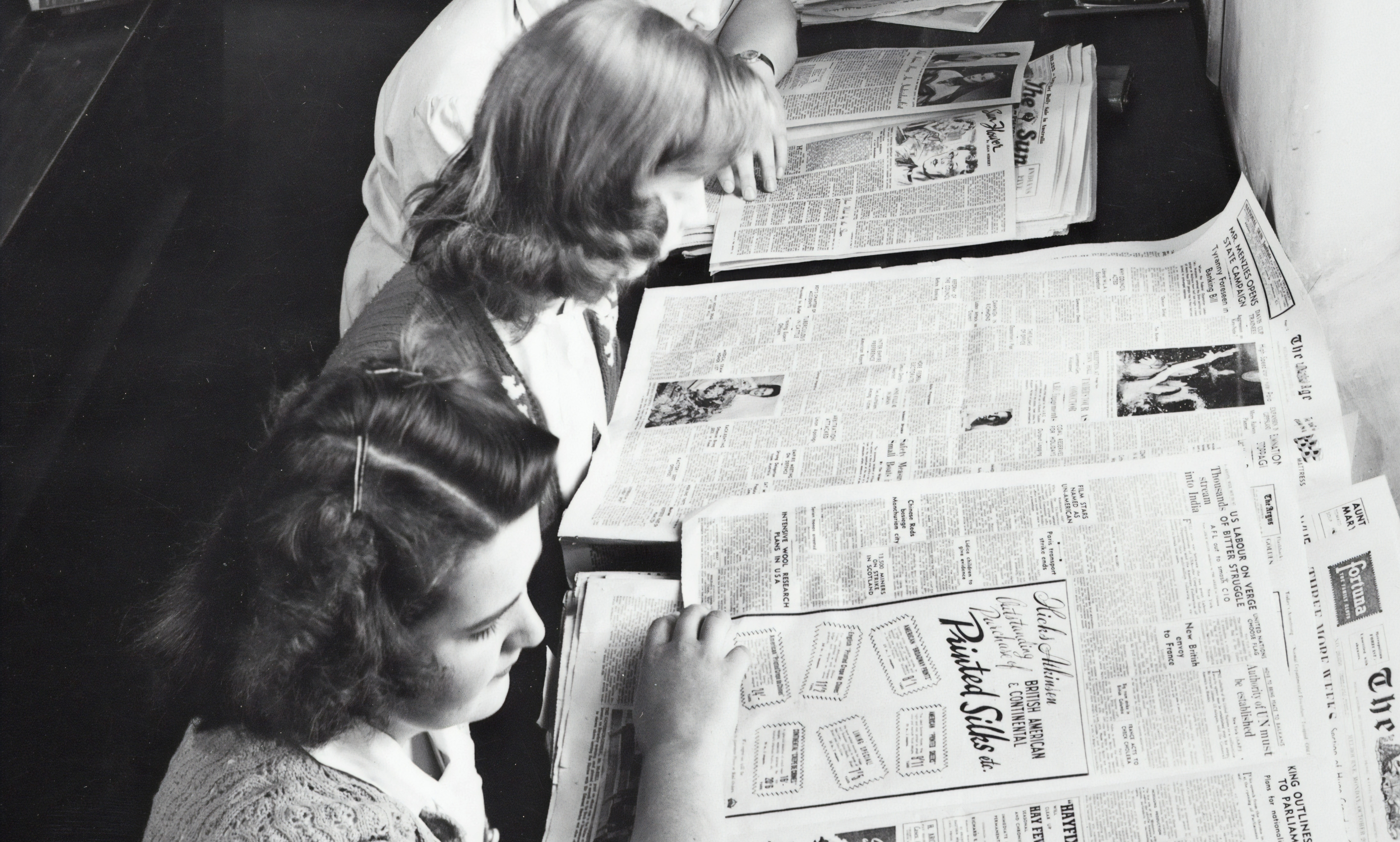 women reading newspapers