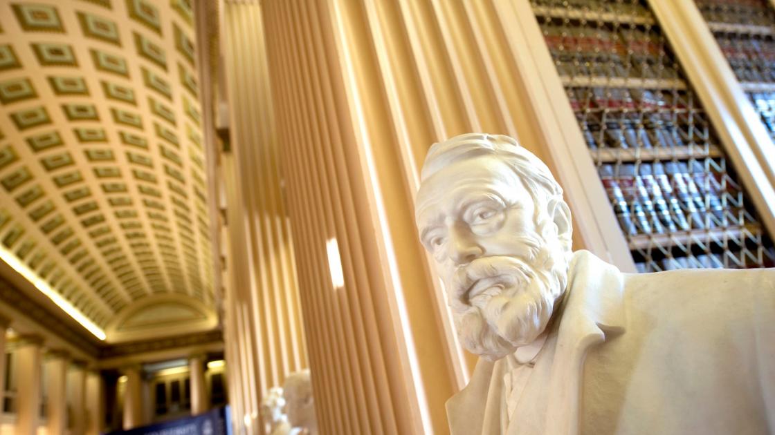 a bust in front of library shelves