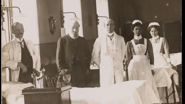 doctors standing around a bed
