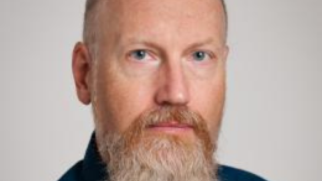 photo of a man with a beard wearing a dark blue shirt