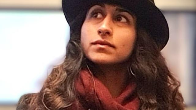 a woman wearing a black bowler hat and a red scarf